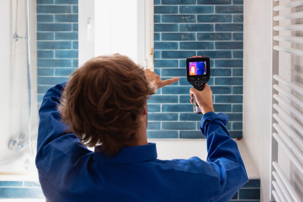 Contractor using infrared diagnostic camera to inspect house